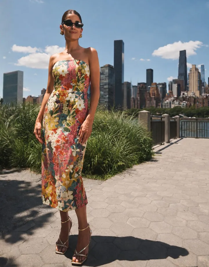 A model in a strapless Mestiza floral midi dress on a riverside promenade in New York