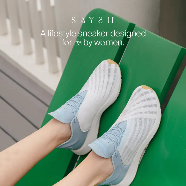 Saysh sneakers worn against a green backdrop