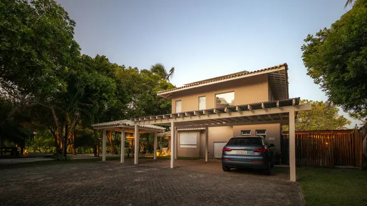 Modern 2-story house at dusk with a car parked under the carport